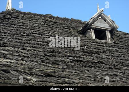 Primo piano di vecchie piastrelle di legno usurate del tetto tradizionale della casa in Romania Foto Stock