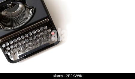 Macchina da scrivere retro nera su sfondo bianco con spazio per la copia del testo. Foto Stock