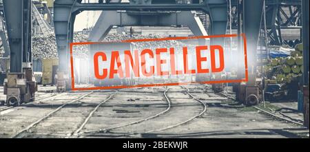 Iscrizione rossa "annullata" su uno sfondo sfocato di carri ferroviari e gru in produzione. Concetto: Crisi economica globale, riduzione degli scambi, Foto Stock