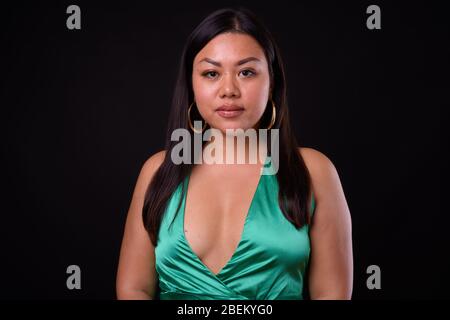 Bella donna asiatica sovrappeso che indossa abito verde seta Foto Stock