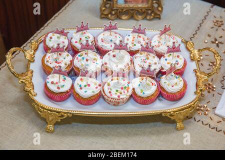 Chiudere vari cupcake gourmet sul vassoio in esposizione . Vassoio d'epoca con belle cupcake. Mini cupcake crema bianca su vassoio primo piano. Vassoio con Foto Stock