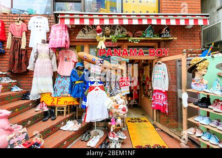 Tokyo, Harajuku, via Takeshita. Panama Boy usato negozio, esterno. Vari vestiti e scarpe fuori negozio su scaffali e appeso a parete. Foto Stock