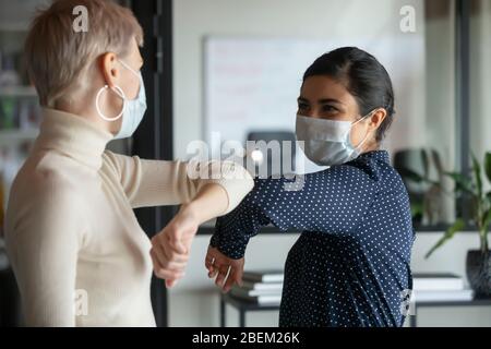 Diversi colleghi salutano i gomiti in ufficio Foto Stock