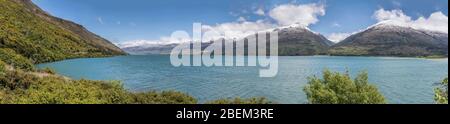 Paesaggio del lago alpino di Wanaka con spiagge verdi e montagne innevate, girato in una luce di primavera brillante dalla spiaggia di Boundary Creek, Otago, South Islan Foto Stock