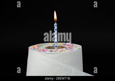 candela di compleanno blu con pallino in rotolo di carta igienica con confetti di caramelle, isolata su nero Foto Stock