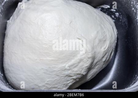 Pasta per pane nel dispenser della macchina per il pane. Appena mescolato pronto a sorgere fresco bianco fatto in casa pizza pasticceria duff cottura processo primo piano Foto Stock