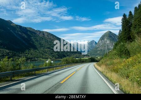 Strada di montagna con il ghiacciaio Josteldalsbreen sullo sfondo, Norvegia Foto Stock