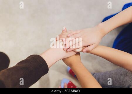 Gruppo di bambini piccoli Uniti le mani insieme vista superiore amicizia e aiuto Foto Stock