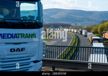 Usti nad Labem, Repubblica Ceca. 14 Aprile 2020. I camion accedano sull'autostrada D8 vicino a Usti nad Labem, Repubblica Ceca, 14 aprile 2020. La coda lunga molti chilometri si è formata grazie alla chiusura dei tubi di destra dei tunnel Panenska di fronte al confine tedesco. Credit: Ondrej Hajek/CTK Photo/Alamy Live News Foto Stock