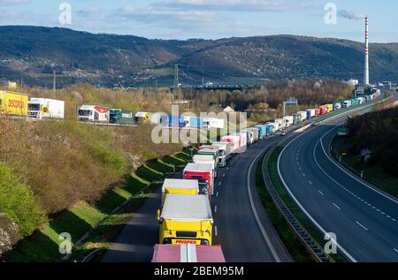 Usti nad Labem, Repubblica Ceca. 14 Aprile 2020. I camion accedano sull'autostrada D8 vicino a Usti nad Labem, Repubblica Ceca, 14 aprile 2020. La coda lunga molti chilometri si è formata grazie alla chiusura dei tubi di destra dei tunnel Panenska di fronte al confine tedesco. Credit: Ondrej Hajek/CTK Photo/Alamy Live News Foto Stock