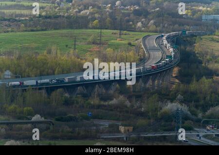 Usti nad Labem, Repubblica Ceca. 14 Aprile 2020. I camion accedano sull'autostrada D8 vicino a Usti nad Labem, Repubblica Ceca, 14 aprile 2020. La coda lunga molti chilometri si è formata grazie alla chiusura dei tubi di destra dei tunnel Panenska di fronte al confine tedesco. Credit: Ondrej Hajek/CTK Photo/Alamy Live News Foto Stock