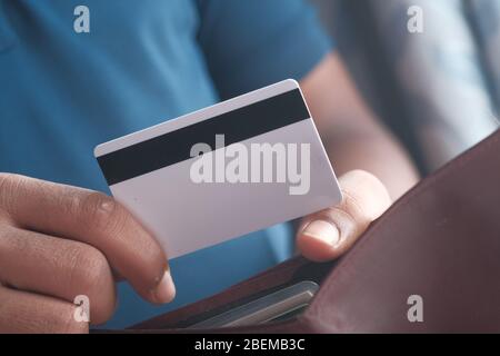 uomo d'affari che dà carta di credito dal portafoglio, primo piano Foto Stock