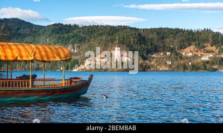 Barca vuota parcheggiata sulla riva del lago di Bled in Slovenia. Barca turistica con primo piano tetto arancione. Bella destinazione di viaggio nelle montagne slovene, Foto Stock