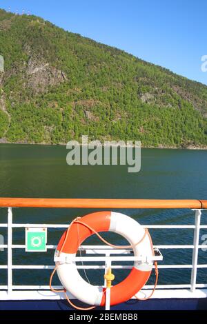 Ponte di una nave e anello di vita mentre naviga lungo il Sognefjord o Sognefjorden, conosciuto come il Re dei fiordi, il fiordo più grande e profondo della Norvegia. Foto Stock