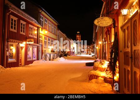 Atmosfera accogliente serale nel Kjerkgata di notte nella storica città mineraria di Røros in inverno, Norvegia Foto Stock