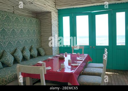 Zona pranzo di una casa sulla spiaggia, turchese, bianco, colore rosa pallet Foto Stock