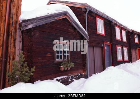 Case tradizionali in legno nella storica città mineraria di Røros in inverno, Norvegia. Foto Stock