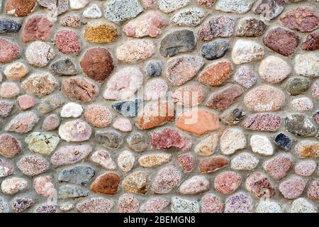 Vista piana di dettaglio di una parete realizzata con pietre diverse. Astratto sfondo di pietra. Foto Stock