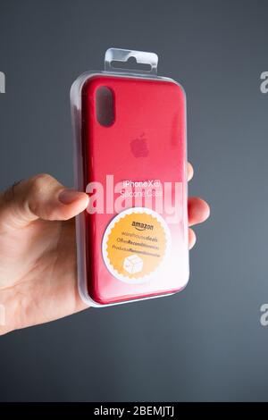 Parigi, Francia - 2 ottobre 2019: POV persona maschile prospettiva personale tenendo contro sfondo grigio pacchetto di proprietà precedente venduto da Amazon Warehouse iPhone XS silicone Case con speciale adesivo arancione Foto Stock