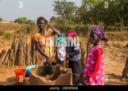 Bissau, Repubblica di Guinea-Bissau - 6 febbraio 2018: Donne e bambini al pozzo per l'acqua, nella città di Bissau, Guinea Bissau Foto Stock