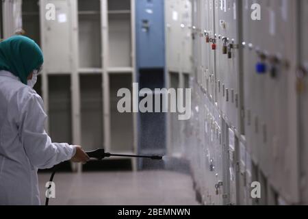 Manouba, Tunisia. 14 Aprile 2020. Donna che pulisce disinfetta il locale spogliatoio il 14 aprile 2020 nella zona industriale di Agba, Manouba, Tunisia. Dopo l'annuncio del contenimento totale in tutta la Tunisia il 22 marzo 2020, fabbriche e settori virali continuano le loro attività nel rispetto delle precauzioni contro la pandemia di CoViD-19. Questa storia segue la routine quotidiana dei lavoratori presso la fabbrica automobilistica Marquardt Tunisia a Manouba, Tunisia, durante la pandemia di coronavirus Covid-19. (Foto di Mohamed KRIT/Sipa USA) Credit: Sipa USA/Alamy Live News Foto Stock