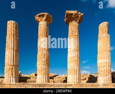 Colonne doriche del tempio degli Eraci ad Agrigento con cielo blu sullo sfondo (Sicilia, Italia) Foto Stock