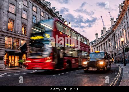 Regent Street, Londra, Inghilterra. Foto in movimento di un tipico autobus rosso a due piani di Londra e taxi, taxi nero. Regent Street è il cuore di Londra Foto Stock