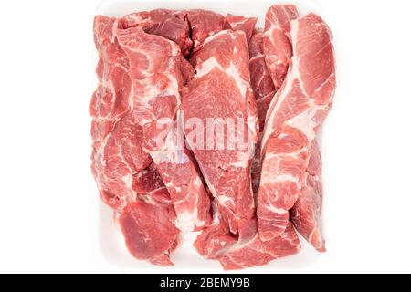 Tagli di carne di maiale cruda in contenitore bianco da vicino isolato su fondo bianco. Sezioni fresche senza osso, vista dall'alto. Foto Stock