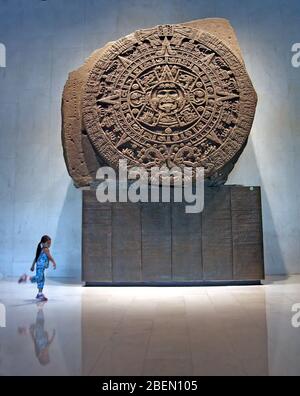 La ragazza balla davanti alla pietra del Sole nel Museo di Antropologia, Città del Messico, Messico Foto Stock