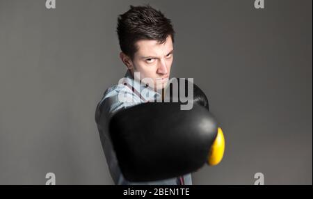 Foto concettuale di un uomo d'affari che si avvicina alla macchina fotografica. È intelligente e rilascia stress, o si prepara alla lotta della sala riunioni. Foto Stock