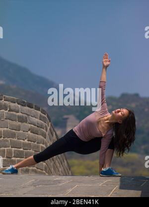 Donna che pratica lo yoga sulla Grande Muraglia Cinese Foto Stock