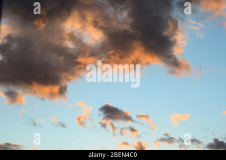 Primo piano di nuvole arancioni scure al tramonto contro il cielo blu . Foto Stock