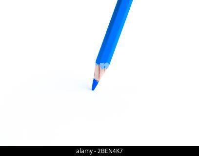 Un singolo pastello a matita di legno blu posto su uno sfondo isolato di carta bianca Foto Stock