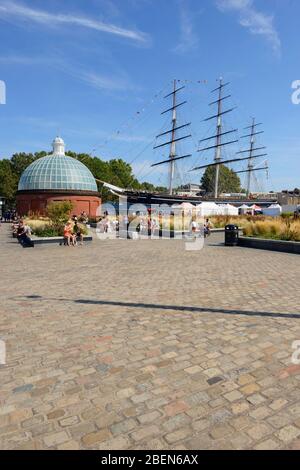 Vista del museo del tagliatè Cutty Sark nel bacino di Greenwich, a sud-est di Londra, Regno Unito, lo scafo racchiuso da un centro visitatori con tetto in vetro Foto Stock