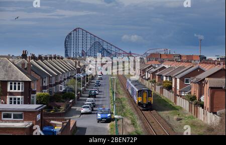 Northern Rail classe 150 + classe 142 a Squires Gate passando le montagne russe e le case a Blackpool Pleasure Beach sulla ferrovia a binario singolo Foto Stock