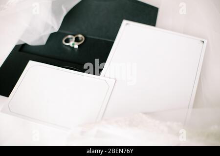 Invito a matrimoni o fidanzamento. Area di scrittura bianca vuota. Anelli di nozze. Tulle su un piano. Foto Stock