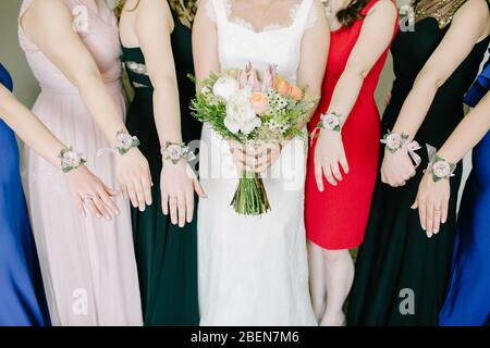 Bouquet nuziale e braccialetti della sposa. Fiori colorati. Interno e primo piano. Foto Stock