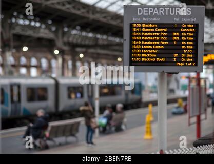 Schermata di partenza alla stazione ferroviaria di Preston con indicazione in tempo, treni cancellati in ritardo, autobus di sostituzione con passeggeri e un treno. Foto Stock