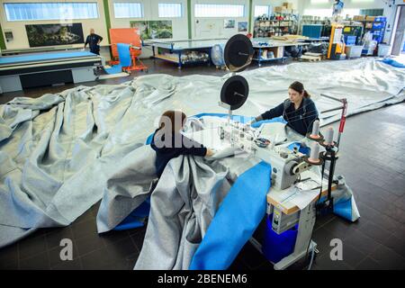 09 aprile 2020, Schleswig-Holstein, Lübeck: Due dipendenti della società di lavorazione del tessuto "geo-die Luftwerker" cuciscono pannelli di tessuto per la prossima installazione dell'artista Christo all'Arco di Trionfo di Parigi. Foto: Gregor Fischer/dpa Foto Stock