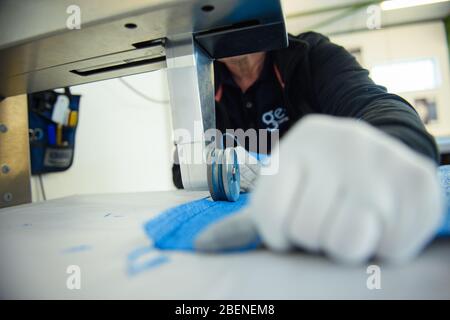 09 aprile 2020, Schleswig-Holstein, Lübeck: Un dipendente della società di lavorazione dei tessuti "geo-die Luftwerker" sta lavorando su un pannello di tessuto per la prossima installazione dell'artista Christo all'Arco di Trionfo di Parigi. Foto: Gregor Fischer/dpa Foto Stock