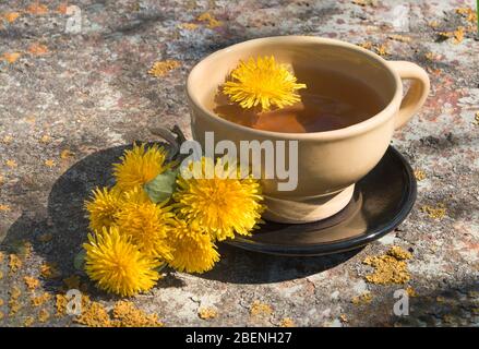 Tè detox fresco fatto in casa da dente di leoni su un tavolo in metallo nel giardino Foto Stock