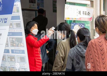 Temperature che prendono prima dell'ingresso, elezioni parlamentari a Seoul, Corea del Sud, 15 aprile 2020, Seoul, Corea del Sud Foto Stock