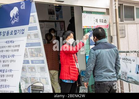 Temperature che prendono prima dell'ingresso, elezioni parlamentari a Seoul, Corea del Sud, 15 aprile 2020, Seoul, Corea del Sud Foto Stock