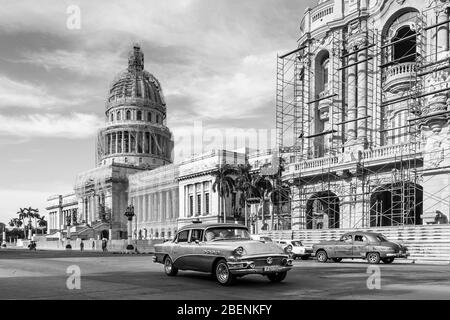 Un paio di vecchi timer colorati viaggiano in direzioni opposte di fronte a El Capitolio, o National Capitol Building a l'Avana, Cuba, nell'agosto 2014. Foto Stock