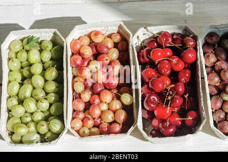 bancarella di frutta biologica con frutta di stagione e bacche nel mercato locale della città. Frutte in cestini di carta sul posto di mercato Foto Stock