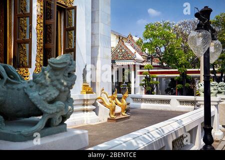 Dragoni dorati accanto all'ingresso del tempio buddista a Bangkok, in Thailandia Foto Stock