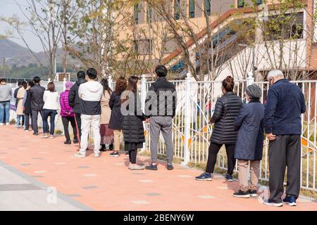 Uiwang si, Corea del Sud. 15 aprile 2020. Persone che indossano maschere facciali come misura preventiva contro la diffusione di coronavirus coda alla stazione di votazione per votare per i loro leader durante le elezioni parlamentari. La Corea del Sud tiene oggi le elezioni parlamentari e sarà il primo paese a tenere elezioni nazionali nel quadro della pandemia di coronavirus. Credit: SOPA Images Limited/Alamy Live News Foto Stock