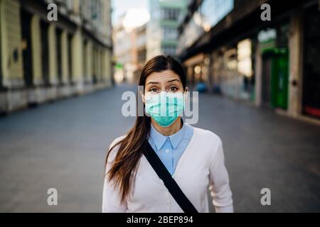 Ansioso giovane adulto colpito dal COVID-19.Walking, andando a lavorare durante pandemic.misure protettive, maschera indossare e sociale di distanziamento.rispettare g Foto Stock