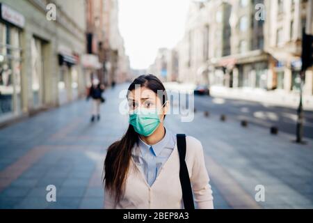 Ansioso giovane adulto colpito dal COVID-19.Walking, andando a lavorare durante pandemic.misure protettive, maschera indossare e sociale di distanziamento.rispettare g Foto Stock