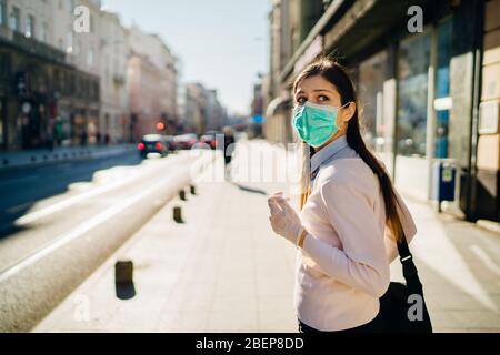 Ansioso giovane adulto colpito dal COVID-19.Walking, andando a lavorare durante pandemic.misure protettive, maschera indossare e sociale di distanziamento.rispettare g Foto Stock